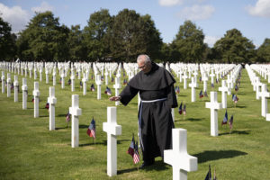 fr. Martin Kobos blessing graves at Normandy American Cemetery